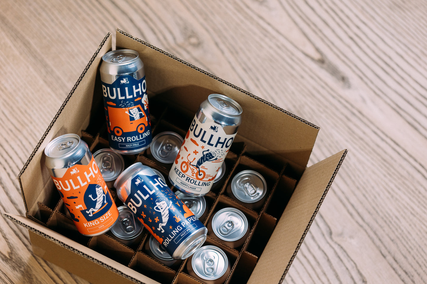 Box of Bullhouse beer cans on a wooden surface