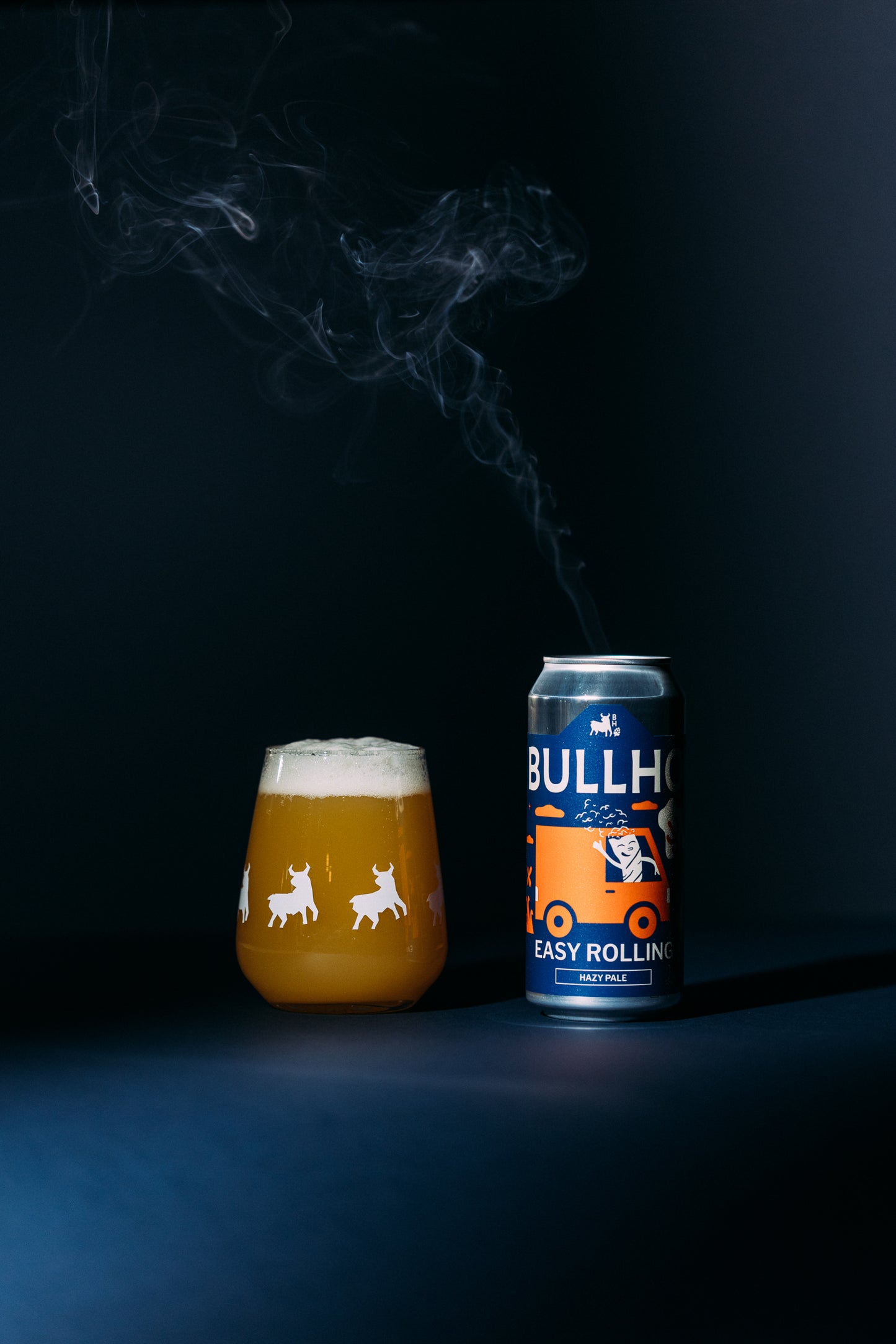 
                  
                    Bullhead beer can and glass with smoke effect on a dark background
                  
                
