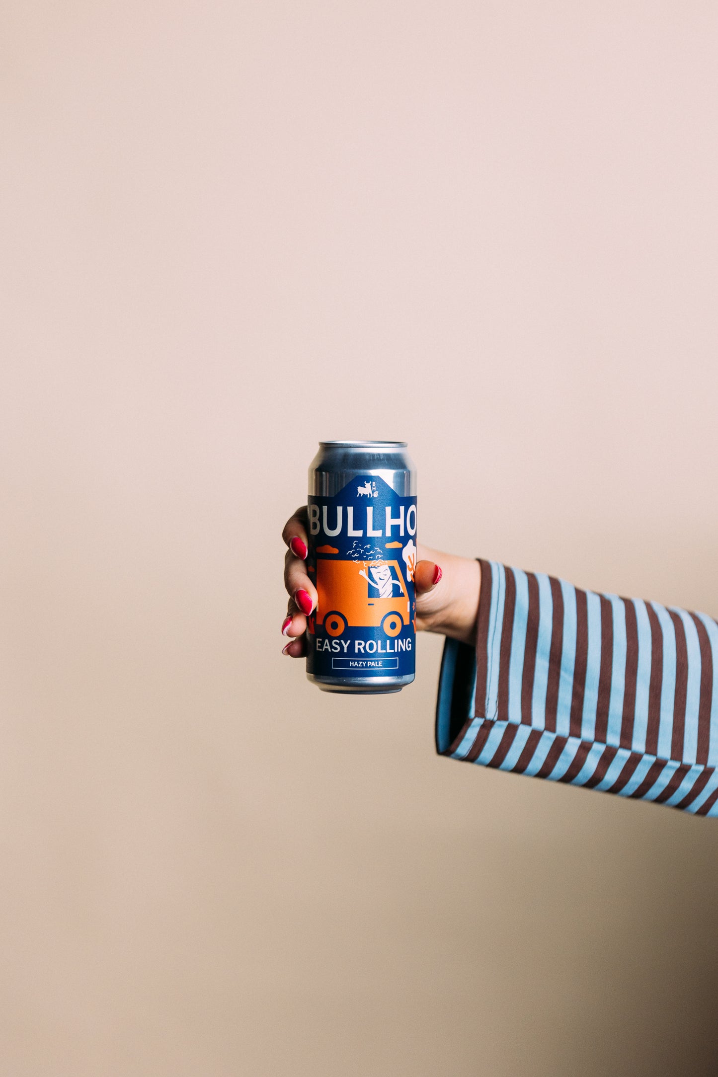 
                  
                    Hand holding a can of Bullhouse Easy Rolling Hazy Pale against a beige background
                  
                